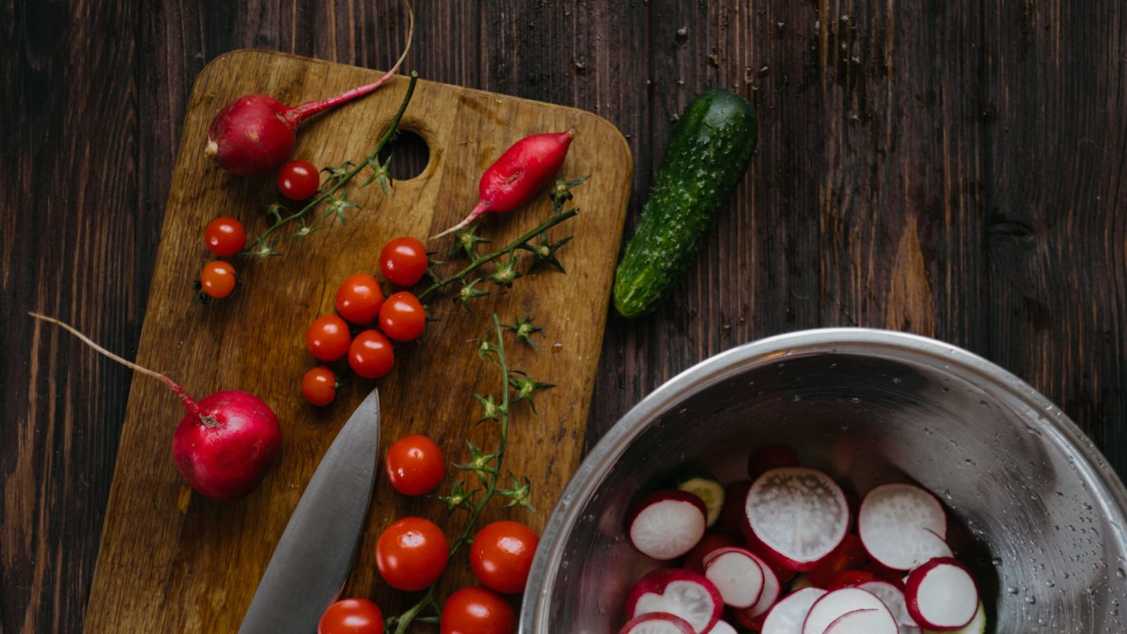 Tomates, radis et légumes frais sur une planche à découper